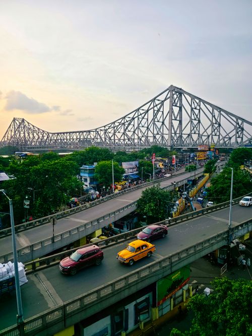Free A vibrant aerial view of Kolkata's iconic Howrah Bridge and city life during the day. Stock Photo