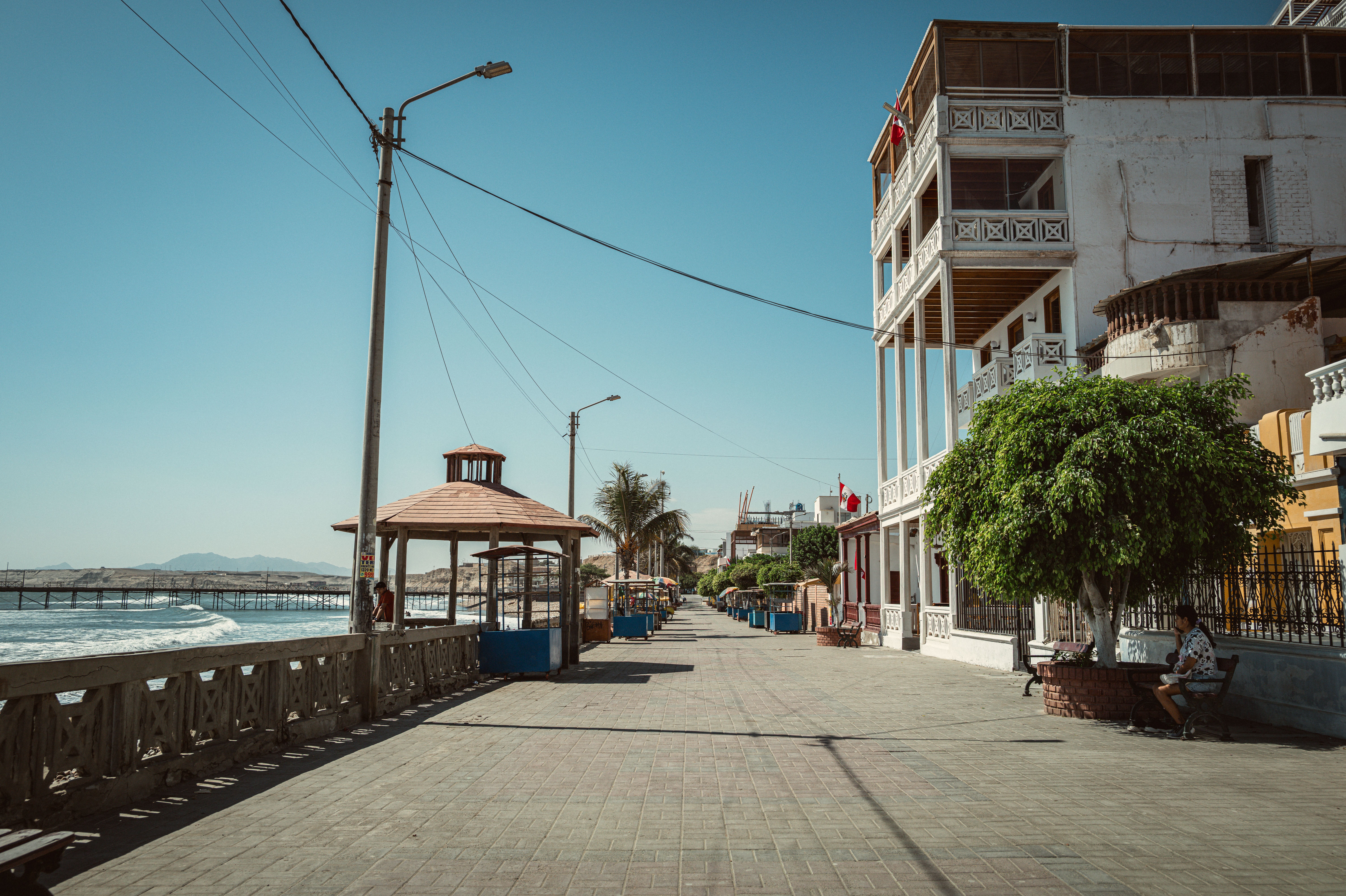 Idyllic beachfront promenade in Pacasmayo, Peru with clear skies and traditional architecture.