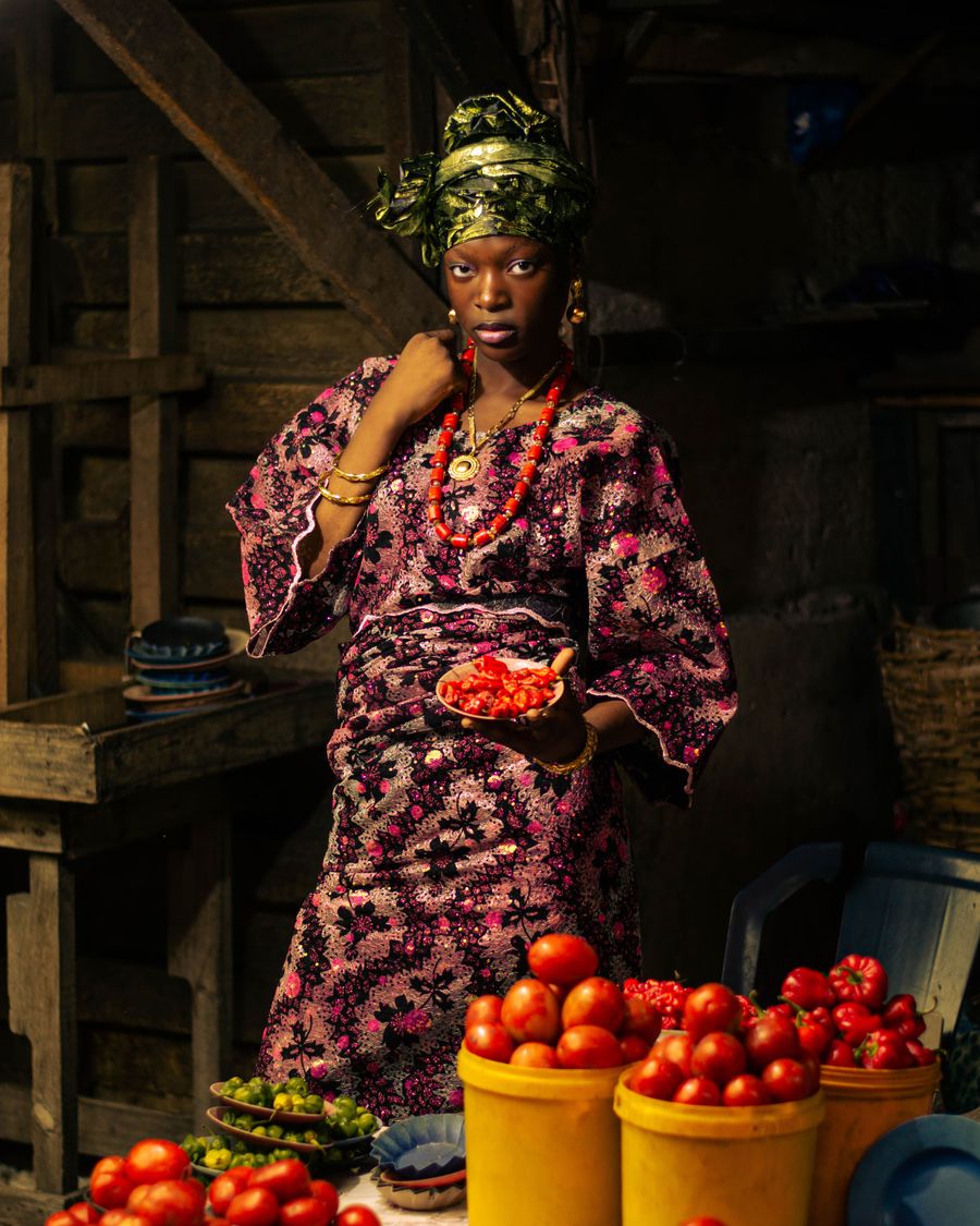 A woman holding red peppers in a Lagos market