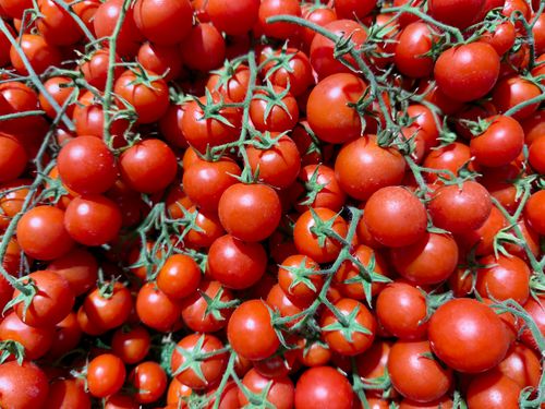 Free A pile of fresh, ripe cherry tomatoes with vivid red hues at a Melbourne market. Stock Photo