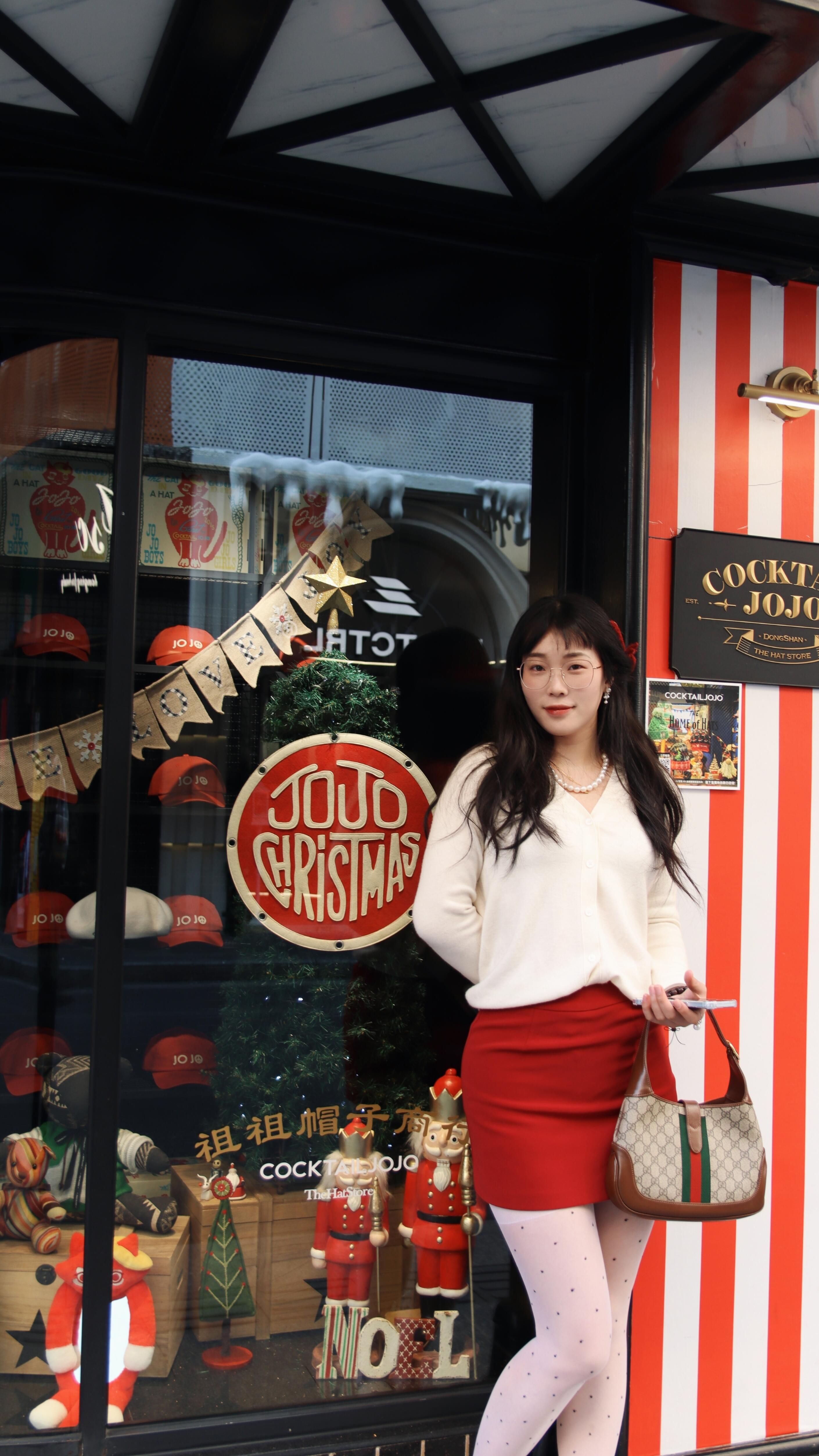 A stylish young woman posing in front of a festive Christmas display in Nanjing, Jiangsu, China.