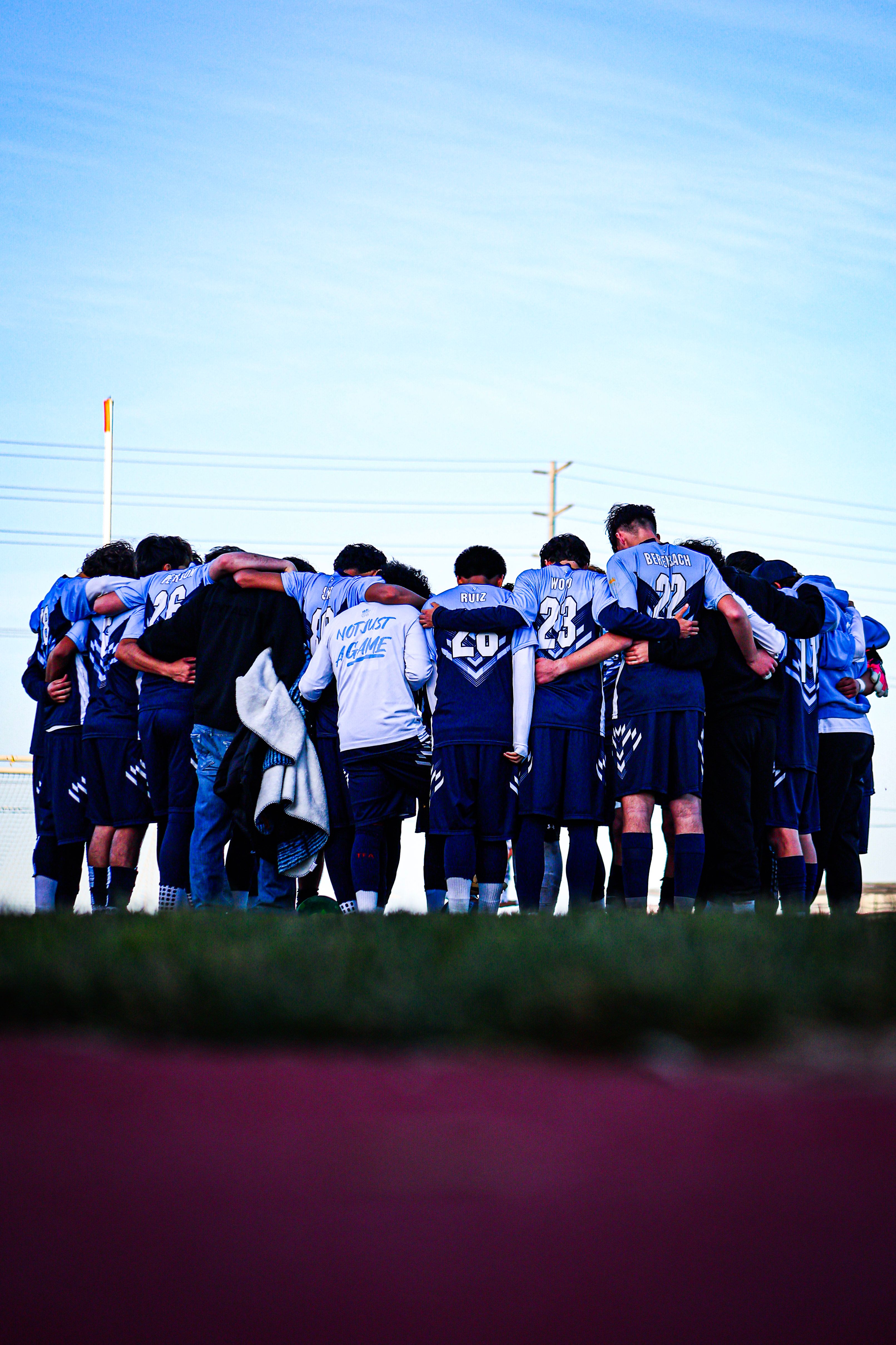 A high school soccer team huddles together