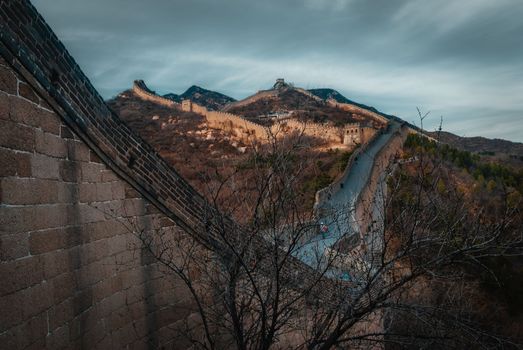 Breathtaking scene of the Great Wall of China winding through rugged mountains at dawn.