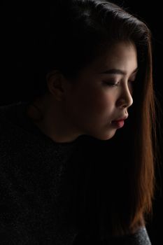 一幅戏剧性的侧面肖像，画中闭眼的女人散发着平静的气息