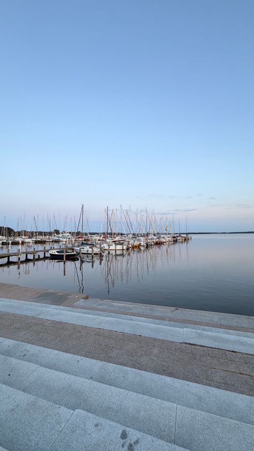 Free Tranquil marina scene with boats docked at sunset in Rerik, Mecklenburg-Vorpommern. Stock Photo