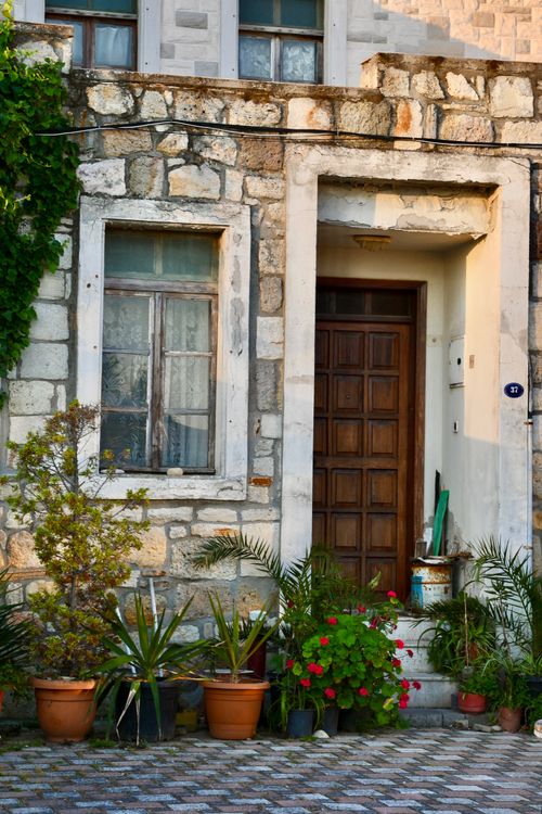 Free Rustic stone house entrance with potted plants in the Mediterranean setting. Stock Photo