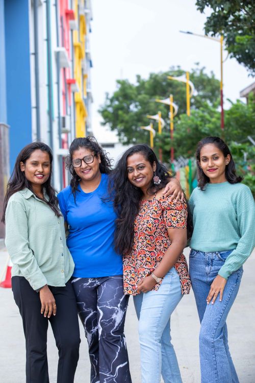 Free Four women smiling and posing together outdoors, showcasing friendship and diversity. Stock Photo