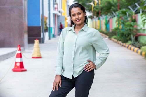 Free Portrait of a confident woman standing outdoors on a vibrant city street. Stock Photo