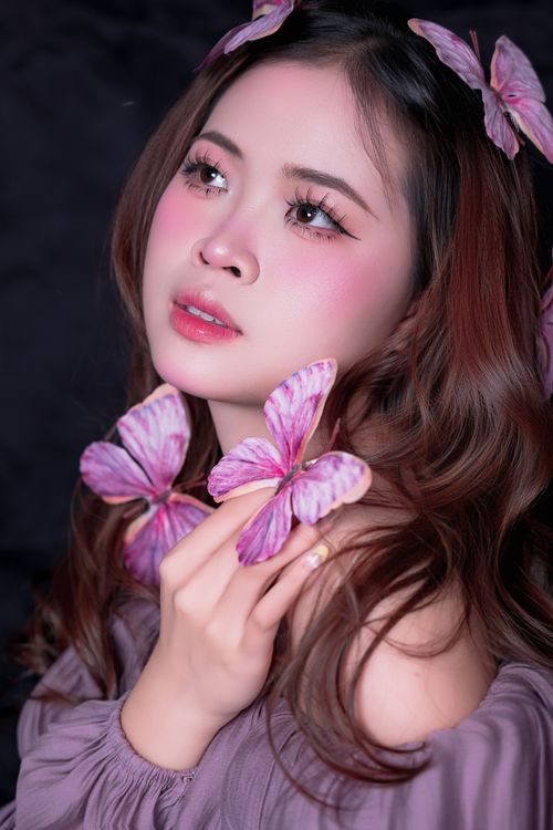 Free Elegant portrait of a young woman with butterflies in soft, pastel colors. Stock Photo