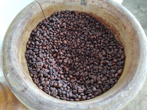 Free A close-up of roasted coffee beans in a rustic wooden bowl, highlighting texture and color. Stock Photo