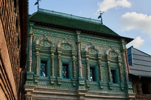 Detailed architectural facade with ornate green tile work on a historic building under a blue sky.