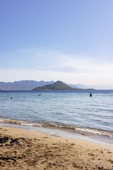 希腊宁静的海滩景色，平静的海水和远处岛屿在湛蓝的天空下若隐若现。 - 相关推荐