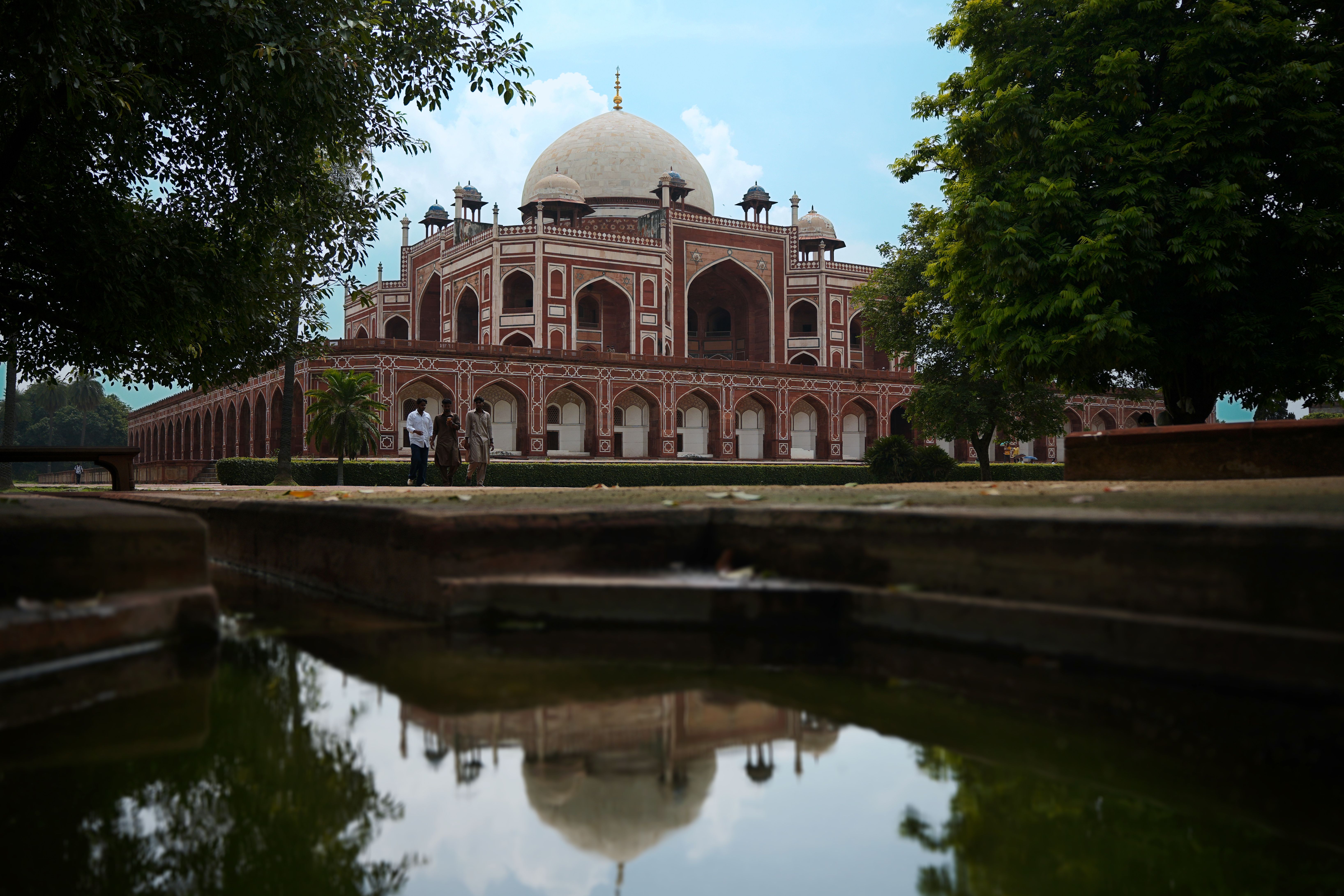 Golden dome and reflecting pool of a Delhi gurudwara at dusk