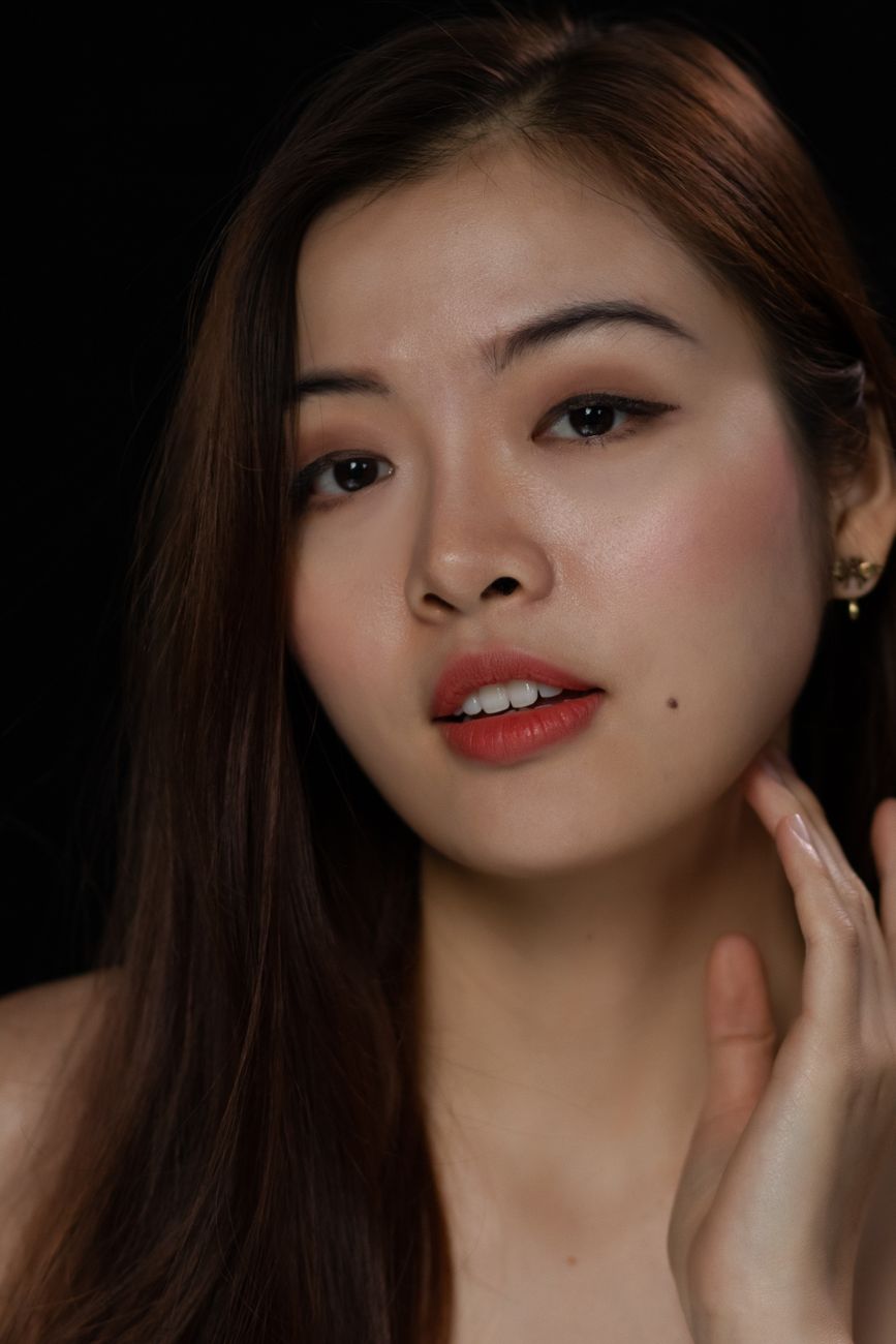 Close-up portrait capturing the natural beauty and elegance of a young woman with captivating eyes and flawless skin.