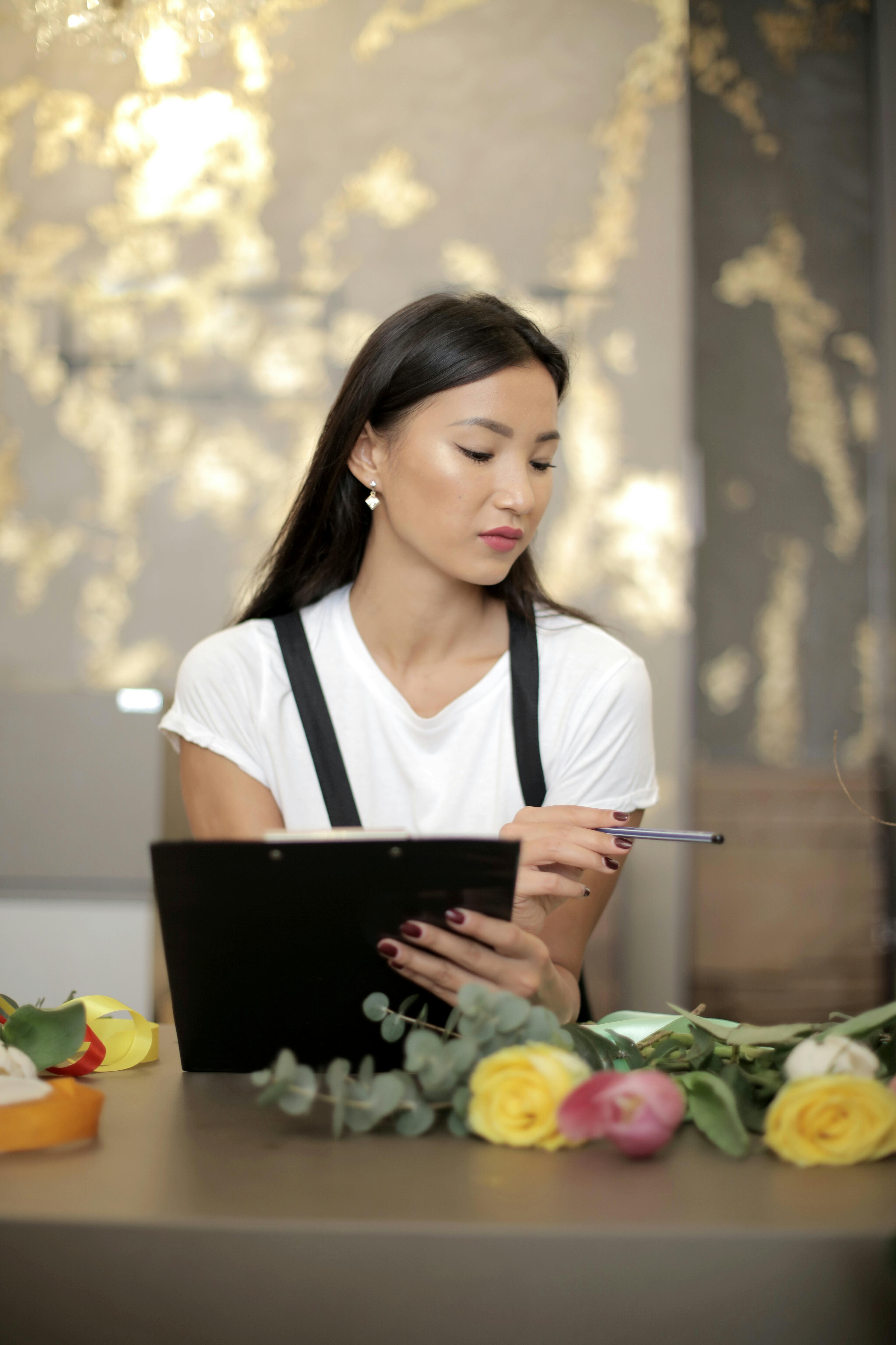 focused young businesswoman counting daily sales in floral shop