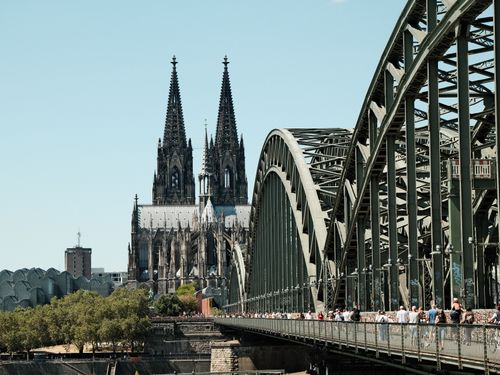 Free Scenic view of Cologne Cathedral and Hohenzollern Bridge on a sunny day with foot traffic. Stock Photo