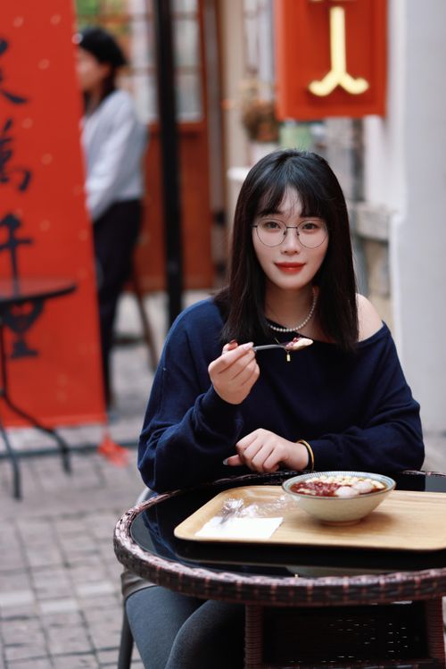 Free Young woman savoring a dessert at an outdoor café in Nanjing, China. Perfect for lifestyle and travel themes. Stock Photo