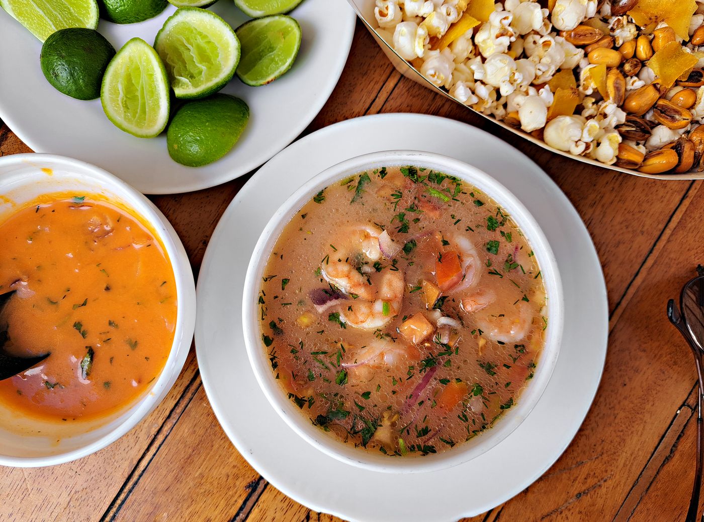 Traditional Ecuadorian shrimp ceviche served with lime, popcorn, and spicy sauce.