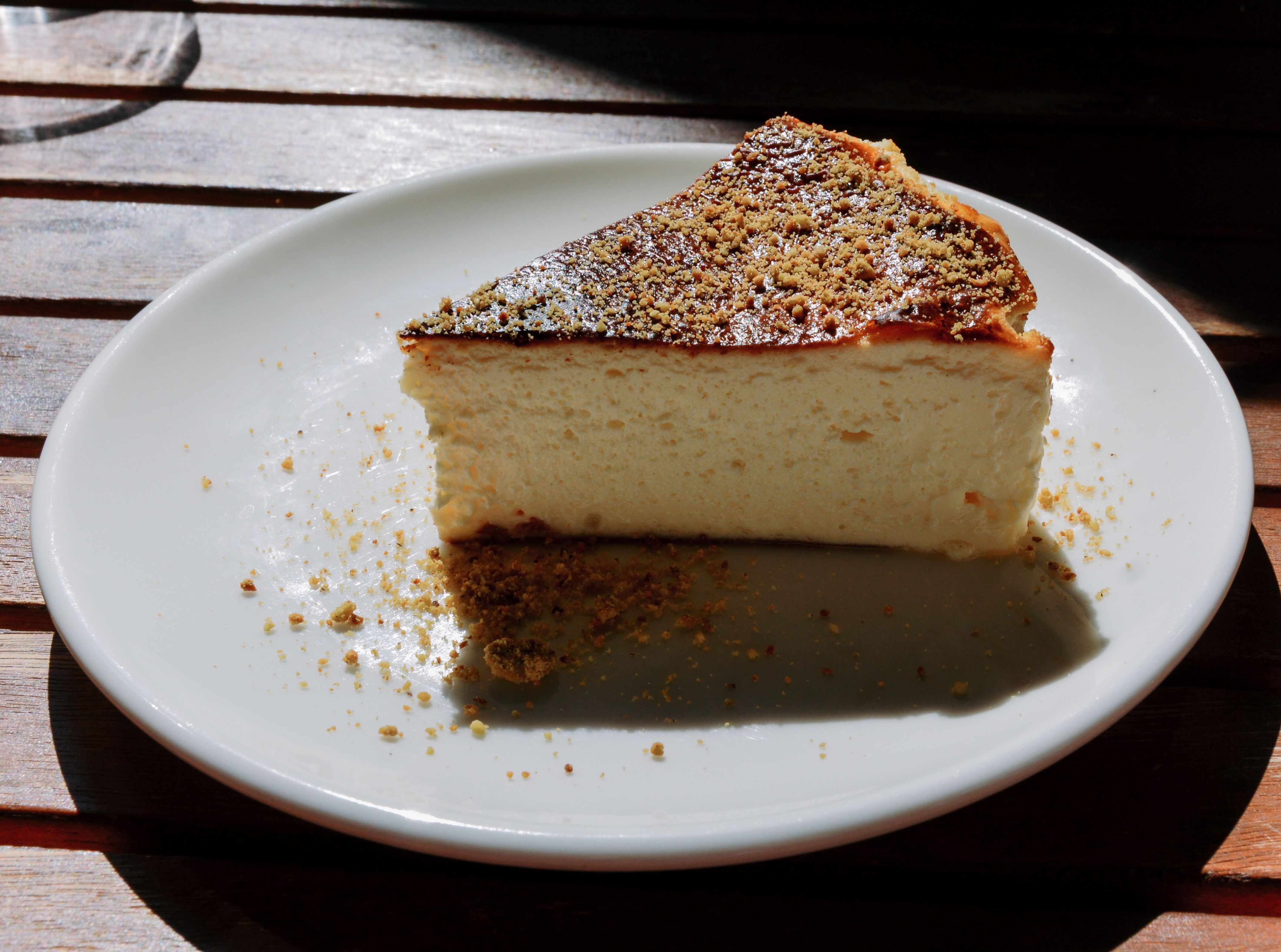 slice of basque burnt cheesecake with a scorched top on a cream plate