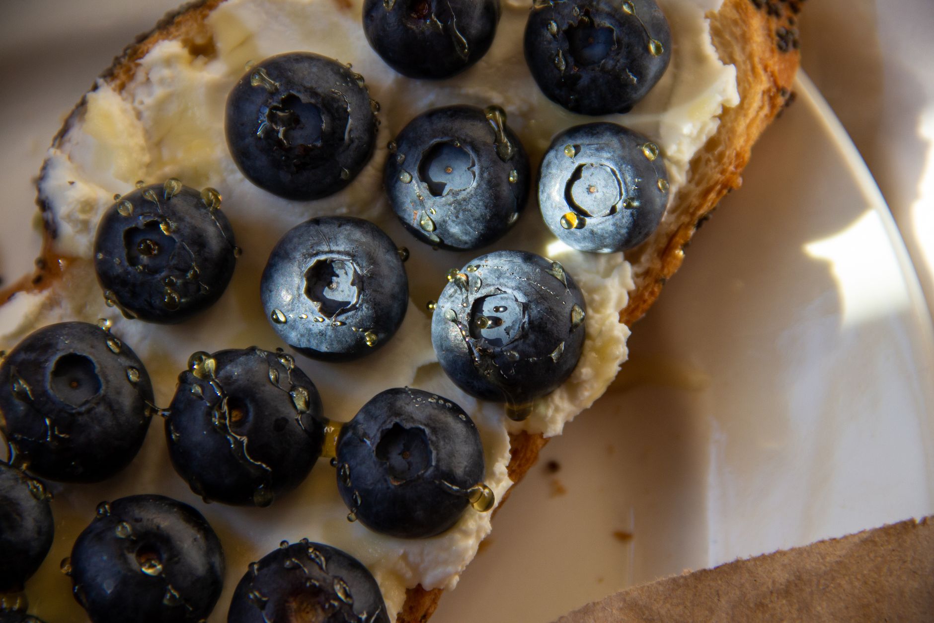 15秒美食短影片腳本庫:10組早餐到甜點實用指南 Crisp toast with cream cheese topped with fresh blueberries and honey drizzles.