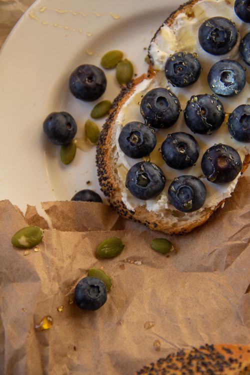 Free Sliced toast topped with blueberries and cream cheese, accompanied by seeds. Stock Photo