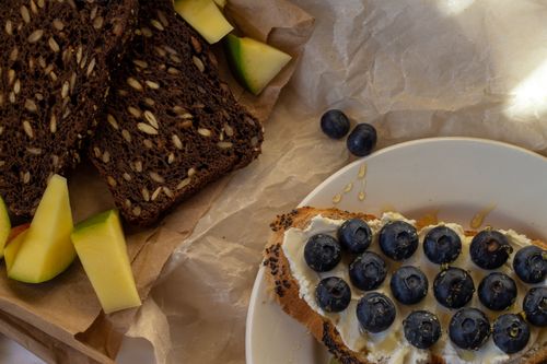 Free A vibrant spread of seeded bread, blueberries, and honey. Perfect for breakfast. Stock Photo