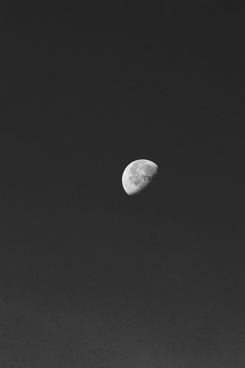 Free A dramatic black and white photo of the moon in the open night sky. Stock Photo