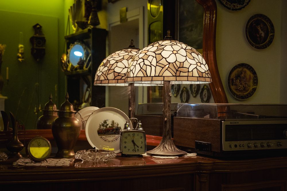 Lampe à abat-jour en vitrail parmi des objets décoratifs dans une boutique d’antiquités