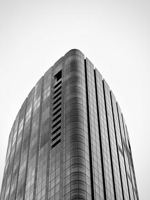 Free Black and white image of a sleek, modern skyscraper showcasing minimalist architecture. Stock Photo
