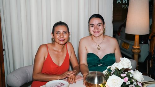 Free Two women enjoying a sophisticated dinner with floral decor indoors. Stock Photo