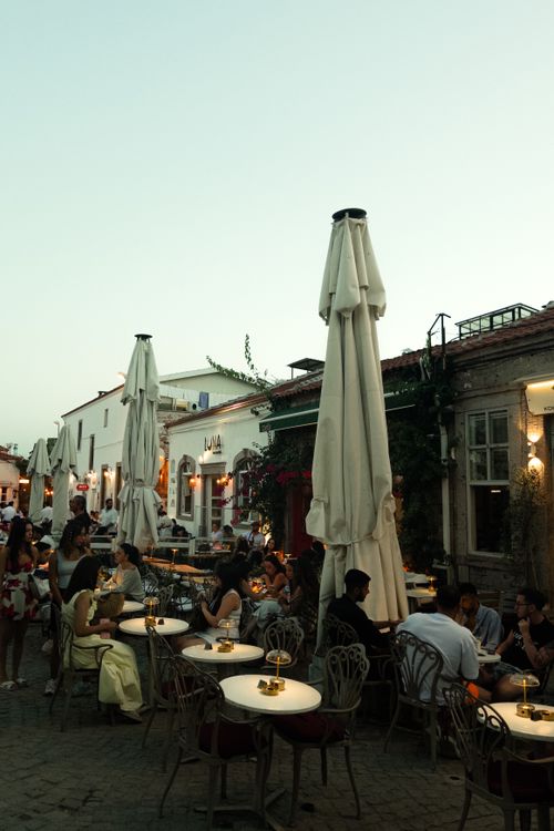 Free Patrons enjoy a relaxed evening at a cozy outdoor café in Balıkesir, Türkiye. Stock Photo