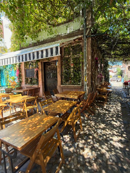 Free Sunlit outdoor café with rustic charm in Balıkesir, Türkiye. Perfect for serene dining. Stock Photo