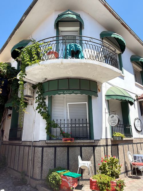 Free Picturesque corner house with balcony and green awnings in Balıkesir, Türkiye. Stock Photo