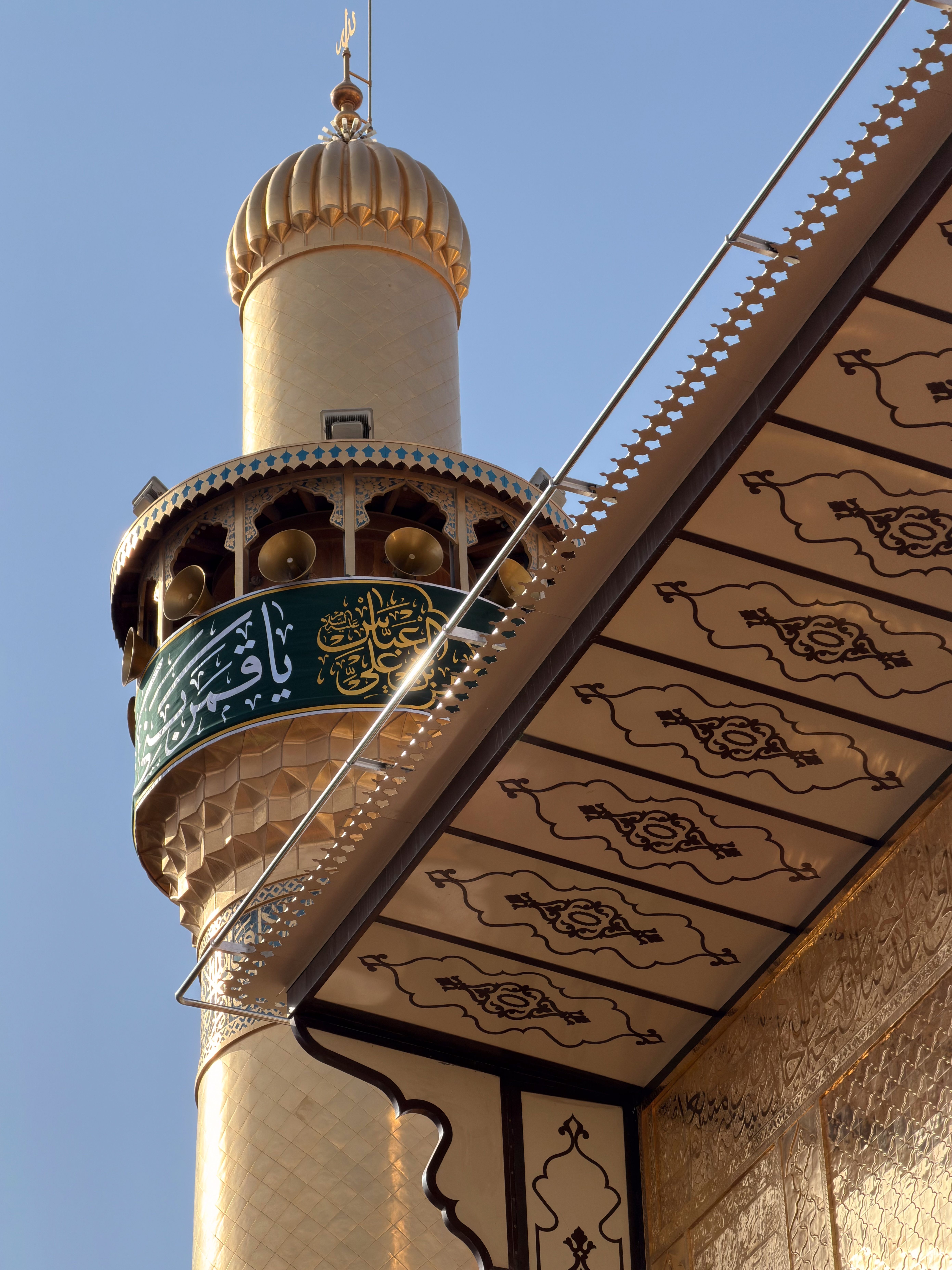 Detail of the gold minaret and ornate awning of Imam Ali Shrine in Najaf, Iraq.