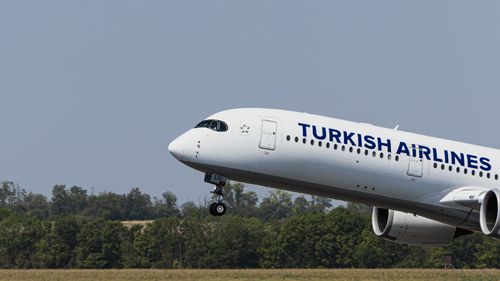 Free A Turkish Airlines passenger plane ascending into the sky, captured on a clear day. Stock Photo