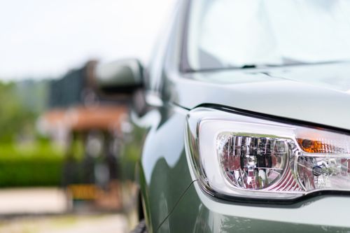 Free Detailed close-up of a modern car headlight, showcasing its design and reflections in bright daylight. Stock Photo