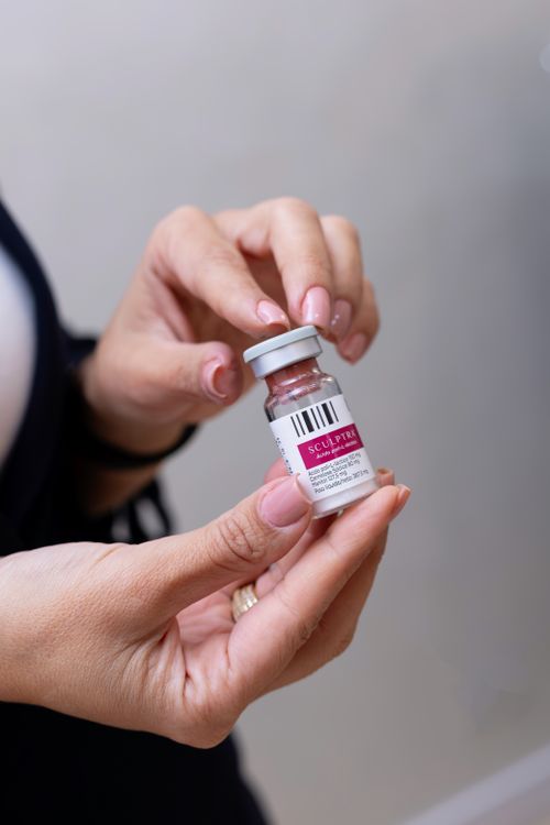 Free Close-up image of hands holding a Sculptra vial, commonly used in cosmetic procedures. Stock Photo