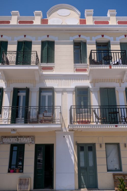 Free Elegant three-story building with balconies showcasing Greek architecture in Skopelos. Stock Photo