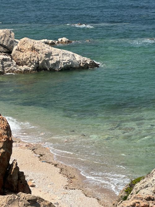 Free Explore the tranquil rocky shoreline meeting the clear turquoise sea. Stock Photo