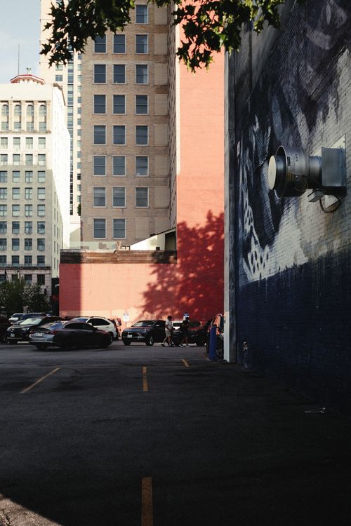 Free City parking lot in Houston with urban graffiti and high-rise buildings under warm daylight. Stock Photo