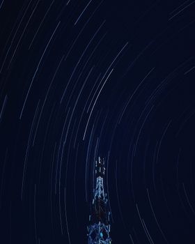 通过长时间曝光，捕捉到了夜空中一座塔上方的戏剧性星迹