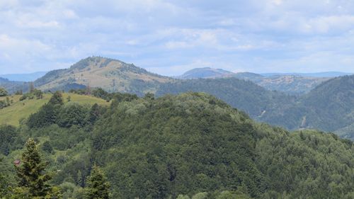 Free Lush green hills and mountains under a bright blue sky capture nature's serene beauty. Stock Photo