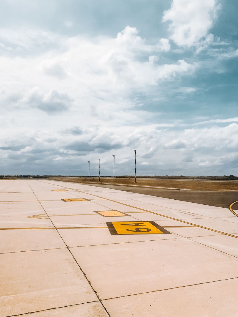 Airport runway marking under cloudy sky
