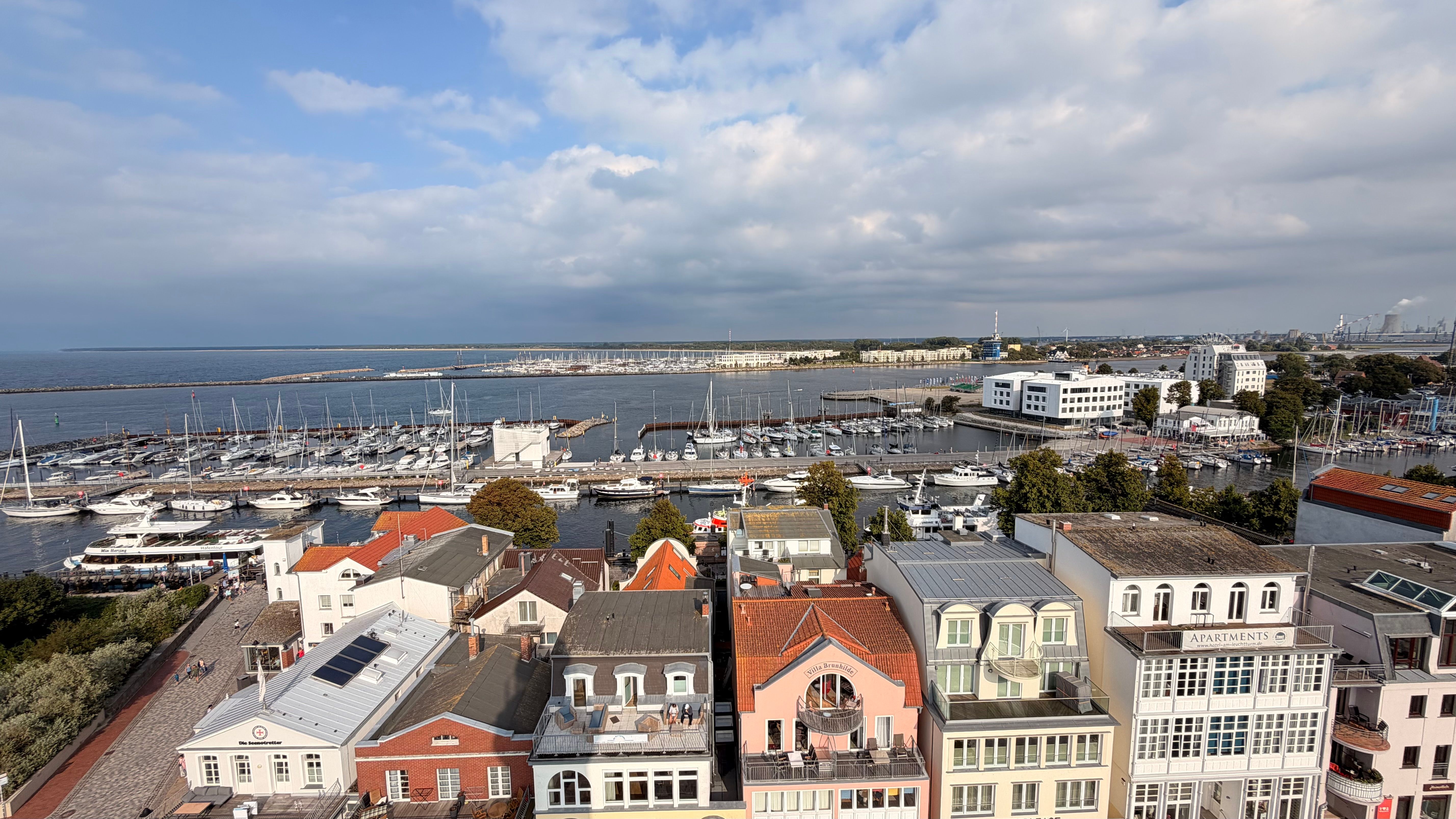 A picturesque view of Rostock's marina and colorful buildings with the Baltic Sea in the background.