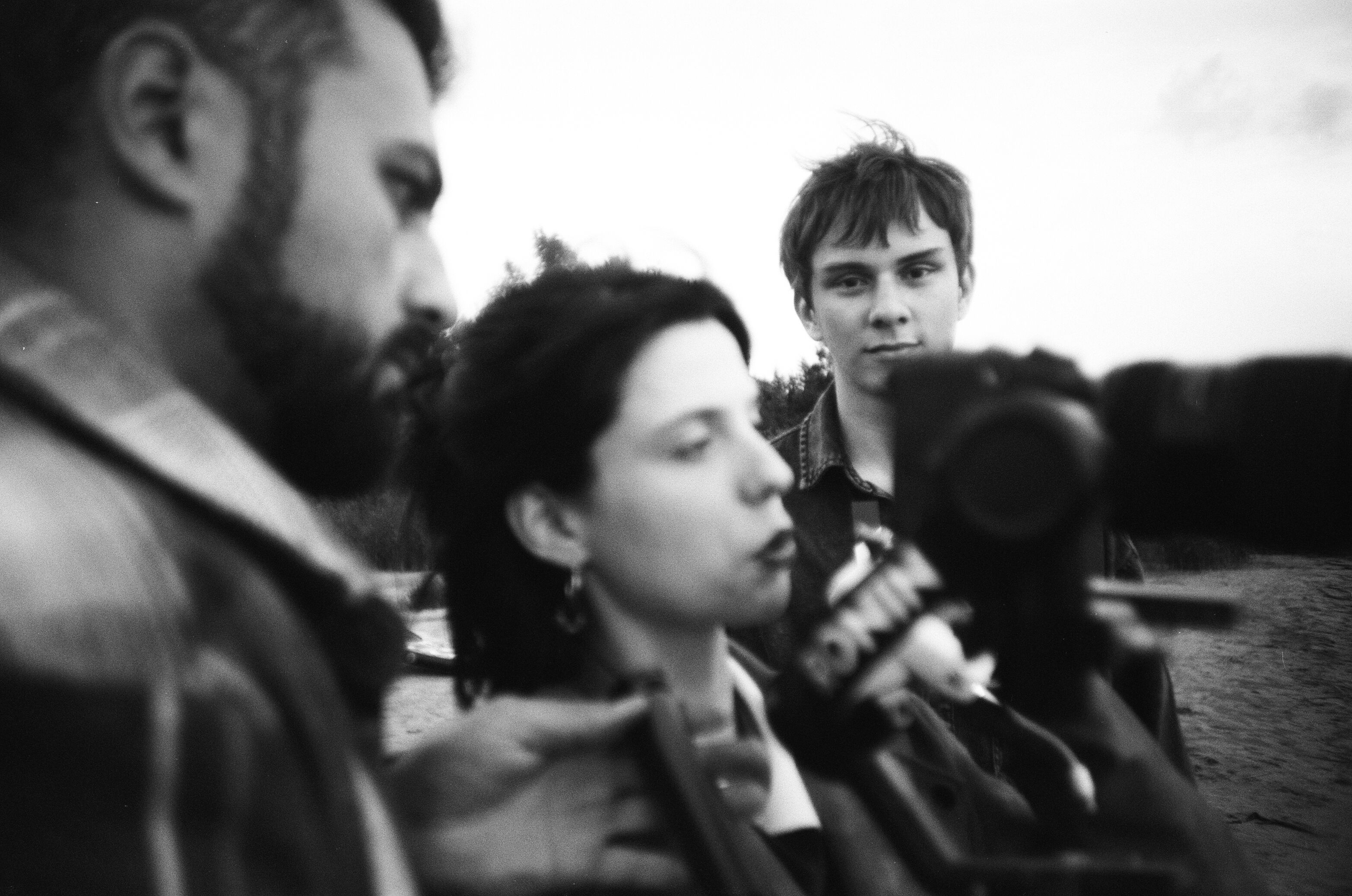 Black and white outdoor media interview with people and camera focus.