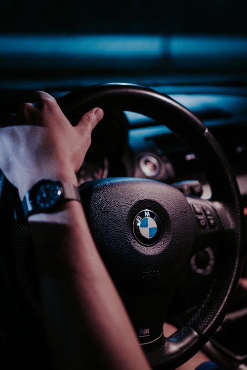 Free Person Holding BMW Steering Wheel Stock Photo