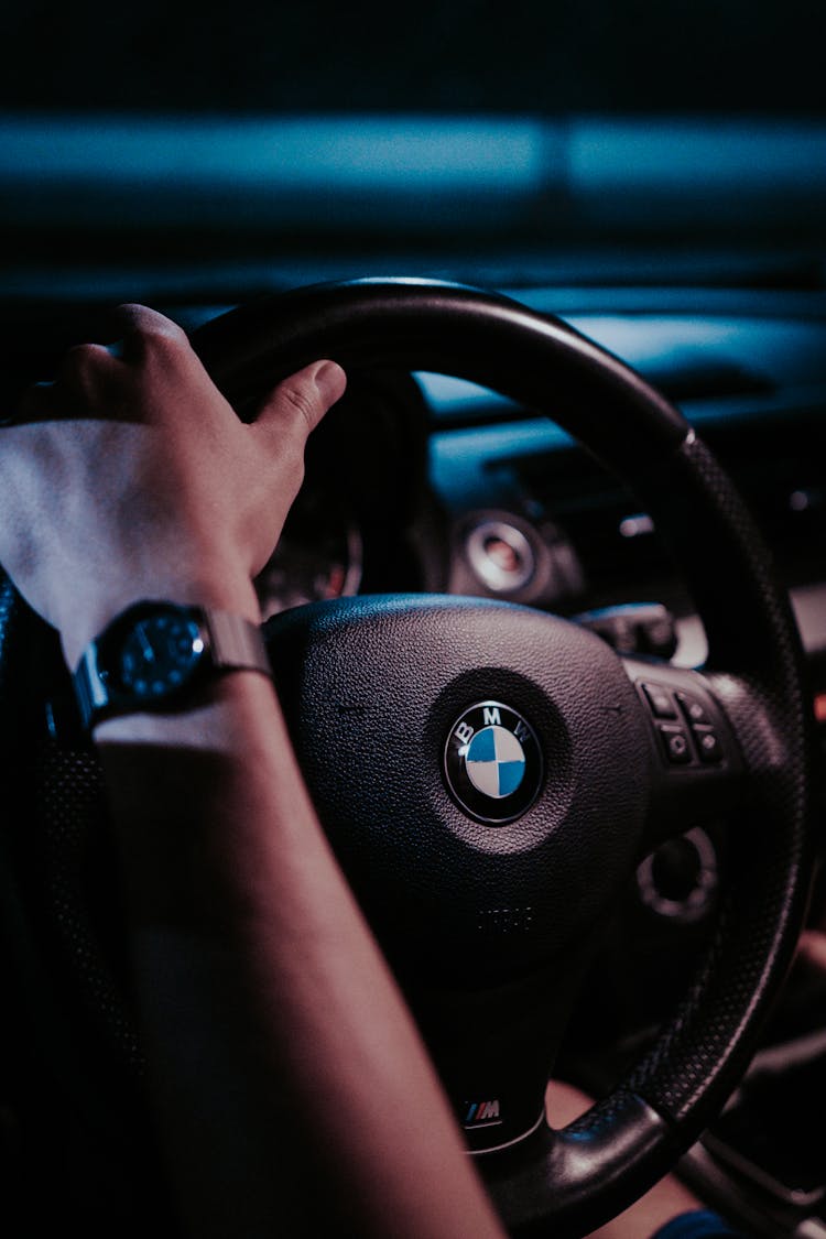 Person Holding BMW Steering Wheel