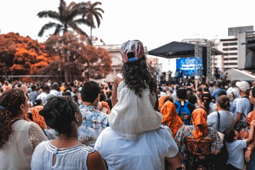 Free A diverse crowd gathered at an outdoor festival with families and music stage. Stock Photo