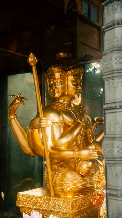 Free A golden multi-armed Hindu deity statue captured in a temple in Ho Chi Minh City, Vietnam. Stock Photo