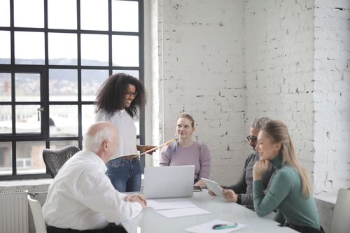 Free A diverse group of professionals working together in a modern office with laptops and tablets. Stock Photo